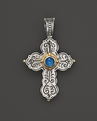 An intricately engraved sterling silver cross pendant embellished with an aquamarine stone and 18K yellow gold. An intricately engraved sterling silver cross pendant embellished with an aquamarine stone and 18K yellow gold.