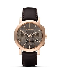 This handsome watch from Burberry features a rose-gold colored case with a subtly textured taupe face, a three-eye analog chronograph dial, and a date window. This handsome watch from Burberry features a rose-gold colored case with a subtly textured taupe face, a three-eye analog chronograph dial, and a date window.
