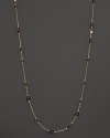 Round and oval grey enamel stations and a diamond highlight this gold chain necklace.