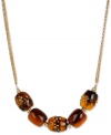 Add uniqueness to your look with this barrel-strung necklace from Kenneth Cole New York. Carved in tortoise resin, they're embellished with pave crystal accents. Crafted in gold tone mixed metal. Approximate length: 18 inches + 3-inch extender. Approximate drop: 3/4 inch.