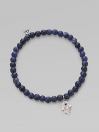 The hamsa, a traditional protective amulet, is encrusted with diamonds and accented with one sapphire as it hangs from a stretchy strand of deep-toned sodalite beads. Diamonds, 0.05 tcw Sodalite 14k white gold Diameter, about 2 (unstretched) Charm length, about ½ Imported