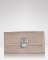 A logo-stamped lock detail toughens up this sleek crocodile-embossed leather wallet. By MICHAEL Michael Kors.