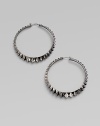 Sterling silver hoops with black rhodium accents have a faceted zigzag pattern all around. Sterling silver and black rhodium Diameter, about 2½ Pierced Imported