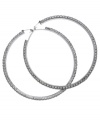 Sparkling and stylish. Large hoop earrings are always a casually chic choice, but GUESS' version goes glam with glittering glass accents. Set in hematite tone mixed metal. Approximate diameter: 2-1/4 inches.