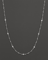 A white gold necklace with bezel-set diamond stations. With signature ruby accent. Designed by Roberto Coin.