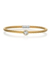 This striking 18K gold and golden cable bracelet, studded with a glittering white topaz station, is perfect for stacking.