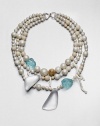 From the Lucite Wanderlust Collection. There are lots to look at in this multi-media design, offering an eclectic mix of shell pearls and richly mottled Petoskey fossil stones with hand-painted, hand-sculpted Lucite shapes, chunks of tinted glass and delicate tendrils of white coral for a head-turning effect.Shell pearlsPetoskey fossil stonesGlassWhite coralLuciteSilk ribbonLength, about 18Hook closeImported