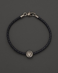 Silver Gucci charm on a braided black natural leather bracelet. Silver Gucci charm on a braided black natural leather bracelet.