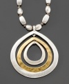 A subtly glamorous necklace inspired by natural motifs. From Kenneth Cole New York, this two tone mixed metal necklace features a fashionable teardrop shaped ringed pendant that hangs from a metal stone 18-inch chain. Comes with a 3-inch extender.