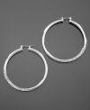 GUESS dresses up classic hoop earrings with sparkling pave crystal details. Crafted in silvertone mixed metal. Approximate diameter: 1-1/2 inches.