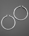 GUESS dresses up classic hoop earrings with sparkling pave crystal details. Crafted in silvertone mixed metal. Approximate diameter: 1-1/2 inches.