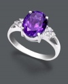 Perfection in purple. Ring features a classic design set in 14k white gold. Center stone features a brilliant oval-cut amethyst (2-1/3 ct. t.w.) and a triangle of three round-cut diamond accents (1/10 ct. t.w.) at the sides.
