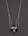A bold sterling silver cage, glistening with diamonds, encases a gleaming black onyx stone. By Di MODOLO.