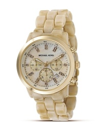 MICHAEL Michael Kors' of the moment chronograph watch has a mother-of-pearl dial with stone indices. The dial features a date window, logo and numeral indices and sweep second hand. Champagne faux-horn band. MICHAEL Michael Kors' of the moment chronograph watch has a mother-of-pearl dial with stone indices. The dial features a date window, logo and numeral indices and sweep second hand. Champagne faux-horn band.