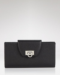 Embrace iconic style with this continental wallet from Salvatore Ferragamo. Crafted from leather and accented with the brand's signature detailing, it flaunts multiple pockets for effortless go-everywhere accessorizing. Embrace iconic style with this continental wallet from Salvatore Ferragamo. Crafted from leather and accented with the brand's signature detailing, it flaunts multiple pockets for effortless go-everywhere accessorizing.