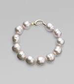 An elegant strand of white organic pearls, with a graceful clasp. 14mm white baroque man-made pearls Length, about 8 18k goldplated sterling silver spring clip clasp Made in Spain