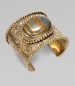 From the Trujillo Collection. An intricately carved, bead-edged cuff, dramatic on its own, has a striated plaque of rainbow calsilica, encased in rock crystal, as its brilliant centerpiece.Rainbow calsilica and rock crystalBronzeDiameter, about 2¼Made in USA