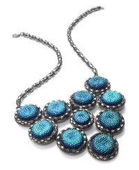Go for glitter and perfect your party look. This festive bib necklace boasts rows of blue plastic cabochon stones with a glittery finish. Crafted in hematite tone mixed metal. Approximate length: 18 inches + 2-inch extender. Approximate drop: 3 inches. Go for glitter and perfect your party look. This festive bib necklace boasts rows of blue plastic cabochon stones with a glittery finish. Crafted in hematite tone mixed metal. Approximate length: 18 inches + 2-inch extender. Approximate drop: 3 inches.