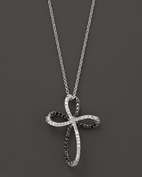 Black and white diamonds, set in 14K. white gold, form an elegant cross. Black and white diamonds, set in 14K. white gold, form an elegant cross.
