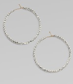 Hoops of 14k gold wire are set with faceted sterling silver beads that catch and reflect light with a warm radiance.14k yellow gold and sterling silverDiameter, about 1½Ear wireMade in USA