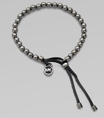 A smooth, beaded design with a logo lock charm and an adjustable leather closure. Gunmetal-finished metalDiameter, about 2.5Slip-on style with adjustable leather closureImported 