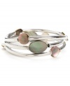 Cool, eclectic and contemporary. Kenneth Cole New York's shimmery bangle set features three, unique styles with round and oval-cut shell accents. Set in silver tone mixed metal. Bracelets stretch to fit wrist. Approximate drop: 2-1/2 inches.