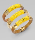 A set of three stunning bangles of natural horn, richly wrapped in brass wire and bright leather cord.Natural cow hornBrassLeatherDiameter, about 2¾Imported