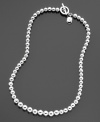 A sophisticated style you'll love: a silvertone graduated ball necklace from Lauren Ralph Lauren with a cute logo charm and toggle closure. Length measures 16 inches.