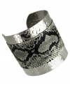 Slink into something fierce. GUESS adds sultry style with this cuff bracelet with a black and white snake print. Crafted from textured imitation rhodium silver tone mixed metal. Approximate diameter: 2-1/4 inches.