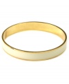 Refined and polished. This versatile piece by Anne Klein pairs perfectly with other bangles for a trendy, layered look. Crafted in gold tone mixed metal with an ivory enamel stripe. Approximate diameter: 2-1/2 inches.