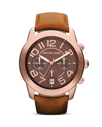 Finished by a classically styled leather strap, this Michael Kors watch flaunts tonal beauty with its rich rose gold plated bezel, chocolate dial, and tony accents. Finished by a classically styled leather strap, this Michael Kors watch flaunts tonal beauty with its rich rose gold plated bezel, chocolate dial, and tony accents.