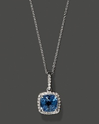 Diamonds frame a faceted blue topaz, set in 14K white gold. Diamonds frame a faceted blue topaz, set in 14K white gold.