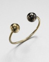 A modern and architectural design featuring two-tone spheres on a narrow cuff. 14k goldplatedGunmetal-finishedDiameter, about 2.4Slip-on styleMade in USA