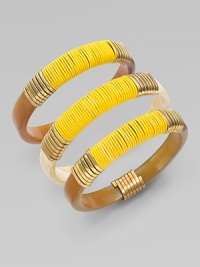 A set of three stunning bangles of natural horn, richly wrapped in brass wire and bright leather cord.Natural cow hornBrassLeatherDiameter, about 2¾Imported