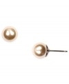 Simple sophistication by Givenchy. Stud earrings feature polished glass pearls in brown gold-plated mixed metal. Approximate diameter: 3/4 inch.