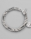 From the Cable Heart Collection. A lovely cable heart framed in pavé diamonds hangs from a figaro chain bracelet of sterling silver. Diamonds, 0.19 tcw Sterling silver Length, about 7½ Toggle closure Imported