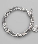 From the Cable Heart Collection. A lovely cable heart framed in pavé diamonds hangs from a figaro chain bracelet of sterling silver. Diamonds, 0.19 tcw Sterling silver Length, about 7½ Toggle closure Imported