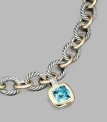 From the Albion Collection. A brilliant blue topaz, richly faceted, surrounded by 18k gold and set in sterling silver. Blue topaz 18k yellow gold and sterling silver About ½ square Hinged clip clasp Made in USA Please note: Necklace sold separately.