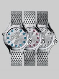 Dazzling topaz stones surround diamond-encrusted numerals on this classic, stainless steel design, featuring a unique rolling gemstone mechanism that changes the semiprecious markers for three different looks, with a single stationary diamond at 12.Swiss quartz movement Water resistant to 3 ATM Round stainless steel case, 38mm, (1.49) Silver dial Topaz and single diamond markers, 2.9 tcw Arabic numeral hour markers Bracelet strap Made in Switzerland Dazzling topaz stones surround diamond-encrusted numerals on this classic, stainless steel design, featuring a unique rolling gemstone mechanism that changes the semiprecious markers for three different looks, with a single stationary diamond at 12.Swiss quartz movement Water resistant to 3 ATM Round stainless steel case, 38mm, (1.49) Silver dial Topaz and single diamond markers, 2.9 tcw Arabic numeral hour markers Bracelet strap Made in Switzerland