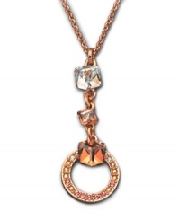 A design that speaks volumes about elegance -- this gold tone mixed metal pendant flaunts a cubic-cut clear Swarovski crystal on top. Followed by two Golden Shadow Swarovski crystals, the pendant ends with a ring of moonlight and golden shadow Swarovski crystals set in pavé. Approximate length: 15 inches. Approximate drop: 2 inches. A design that speaks volumes about elegance -- this gold tone mixed metal pendant flaunts a cubic-cut clear Swarovski crystal on top. Followed by two Golden Shadow Swarovski crystals, the pendant ends with a ring of moonlight and golden shadow Swarovski crystals set in pavé. Approximate length: 15 inches. Approximate drop: 2 inches.