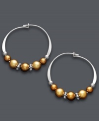 A tri-color blend spices up a traditional pair of hoop earrings. Jody Coyote's unique design offers a metallic mix of copper and gold Austrian crystal pearls threaded onto delicate, sterling silver hoops. Approximate diameter: 3/4 inch.