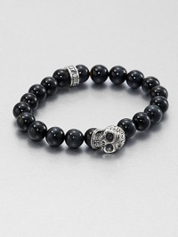 A striking skull pendant of sterling silver accents a stretch beaded bracelet of blue tigers' eye for the modern man of style.Sterling silverTigers' eyeWidth, about 10mmDiameter, about 3Made in USA A striking skull pendant of sterling silver accents a stretch beaded bracelet of blue tigers' eye for the modern man of style.Sterling silverTigers' eyeWidth, about 10mmDiameter, about 3Made in USA