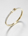 From the Buckle Collection. Encrusted with rhinestones on half, smooth and polished on the other, this graceful bangle is topped with a gleaming golden buckle accent.GlassGoldtoneDiameter, about 2.5Hinged with push-lock claspImported
