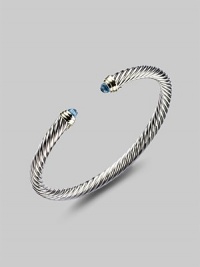 From the Color Classics Collection. A graceful sterling silver cable, capped with faceted blue topaz domes and accents of 14k gold. Blue topaz Sterling silver and 14k yellow gold Cable, 5mm Diameter, about 2¼ Imported