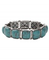 Naturally inspired. Fossil's reconstituted turquoise bracelet has an organic look and feel. Set in silver tone mixed metal with open back castings. Bracelet stretches to fit wrist. Approximate diameter: 2-1/4 inches.