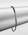 A simple chic piece that features faceted beads in blackened sterling silver accented with four, 14k gold beaded sections. Blackened sterling silver14k goldDiameter, about 2.5Slip-on styleMade in USA