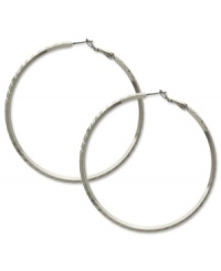 Sophisticated in silver. These classic hoop earrings from GUESS showcase subtle texture for added style. Crafted in silver tone imitation rhodium mixed metal. Approximate diameter: 2-1/2 inches. Sophisticated in silver. These classic hoop earrings from GUESS showcase subtle texture for added style. Crafted in silver tone imitation rhodium mixed metal. Approximate diameter: 2-1/2 inches.