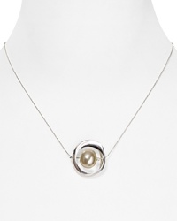 Luminous silver plated metal orbits around a delicate faux pearl on this Robert Lee Morris Soho pendant, forming a suspended statement piece. Luminous silver plated metal orbits around a delicate faux pearl on this Robert Lee Morris Soho pendant, forming a suspended statement piece.