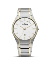This Skagen watch works the two-tone trend in minimalist style, classically crafted of plated stainless steel with tony, gold accents. This Skagen watch works the two-tone trend in minimalist style, classically crafted of plated stainless steel with tony, gold accents.