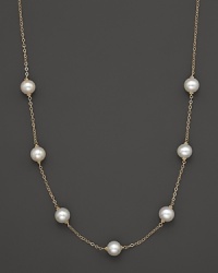 A gold chain necklace with seven freshwater pearl stations. A gold chain necklace with seven freshwater pearl stations.
